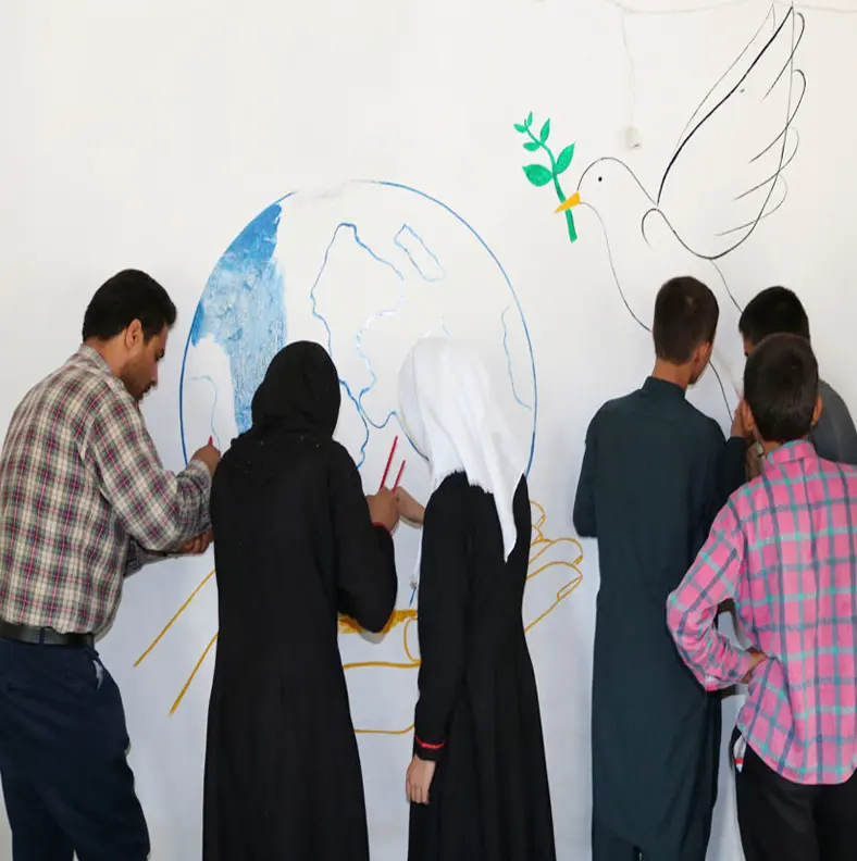 People drawing on a wall images related to peace and reconciliation