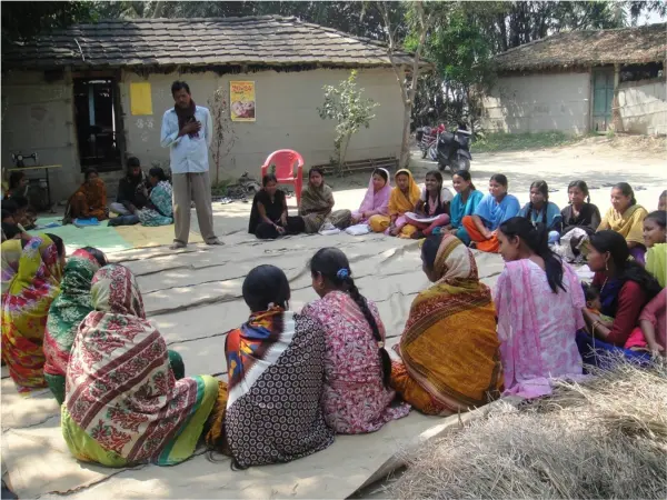 A group of people sitting together in a rural area pics used in the Social Protection page of JRDS website