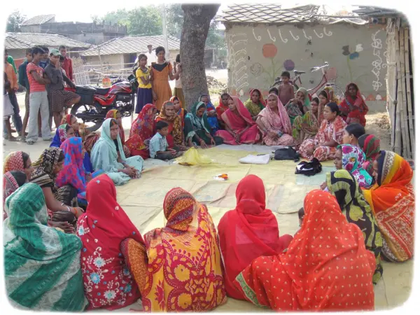 A group of people sitting together in a rural area picss used in the Social Protection page of JRDS website